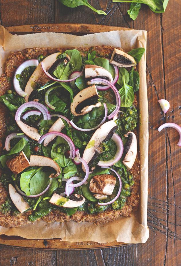 This pizza will hit the spot, it's satisfying, with the right amount of pesto and flavor. Jam packed with nutrients and one of many meals to share with the family after holidays full of sweets. NeuroticMommy.com #vegan #raw #healthy #pizza