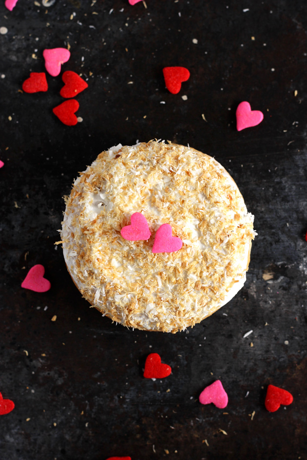 Valentine's Day Toasted Coconut Doughnuts - Fluffy cream filled doughnuts topped with toasted coconut shreds and loving hearts. Perfect for Valentine's Day! NeuroticMommy.com #vegan #donuts #valentinesday