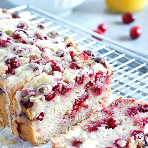 Luscious cranberry loaf cake drizzled with a sweet orange glaze. The perfect addition to the holiday dessert menu. NeuroticMommy.com #vegan #veganthanksgiving 