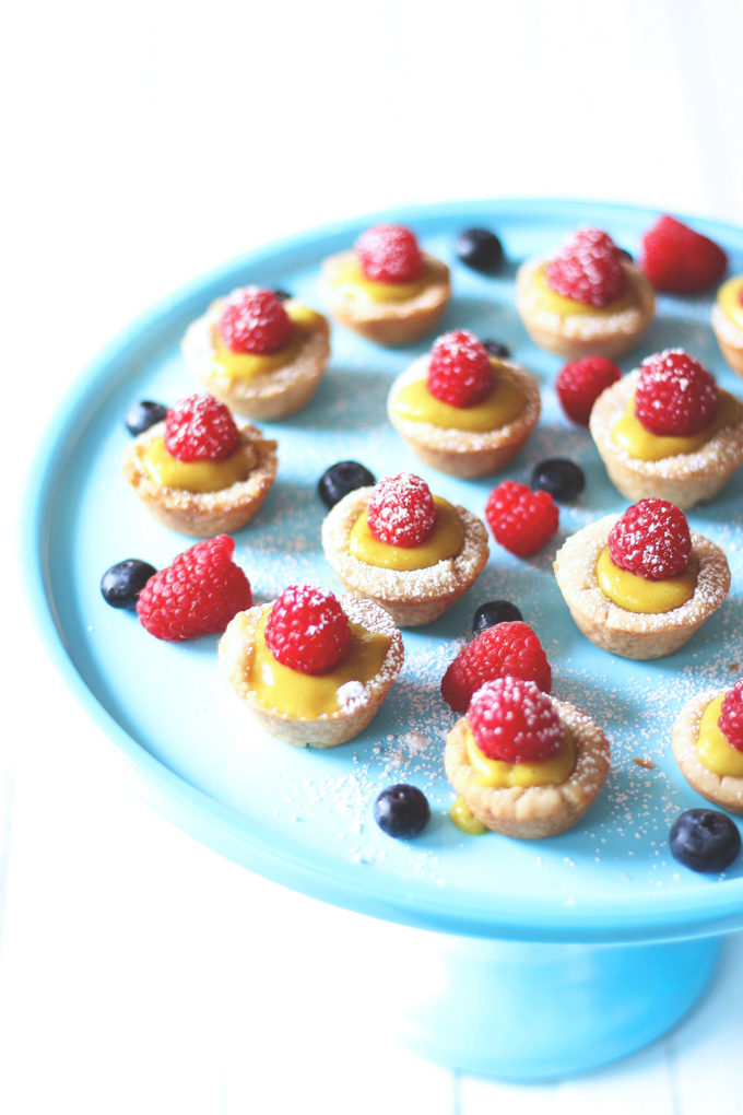 Mini Vegan Custard Tarts With Raspberry - These tarts are made with a cake crust and filled with a creamy, dreamy, heavenly vegan custard. Topped off with fresh raspberries and powdered coconut shreds for extra sparkle, making these bites sugar freakin' free! NeuroticMommy.com #vegan #healthysnacks