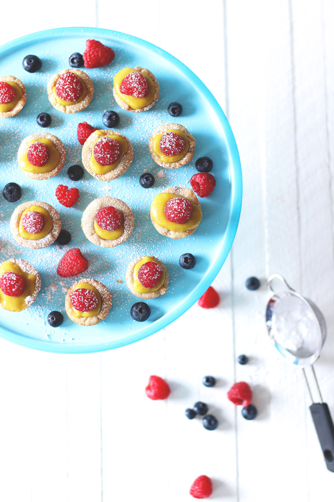 Mini Vegan Custard Tarts With Raspberry - These tarts are made with a cake crust and filled with a creamy, dreamy, heavenly vegan custard. Topped off with fresh raspberries and powdered coconut shreds for extra sparkle, making these bites sugar freakin' free! NeuroticMommy.com #vegan #healthysnacks