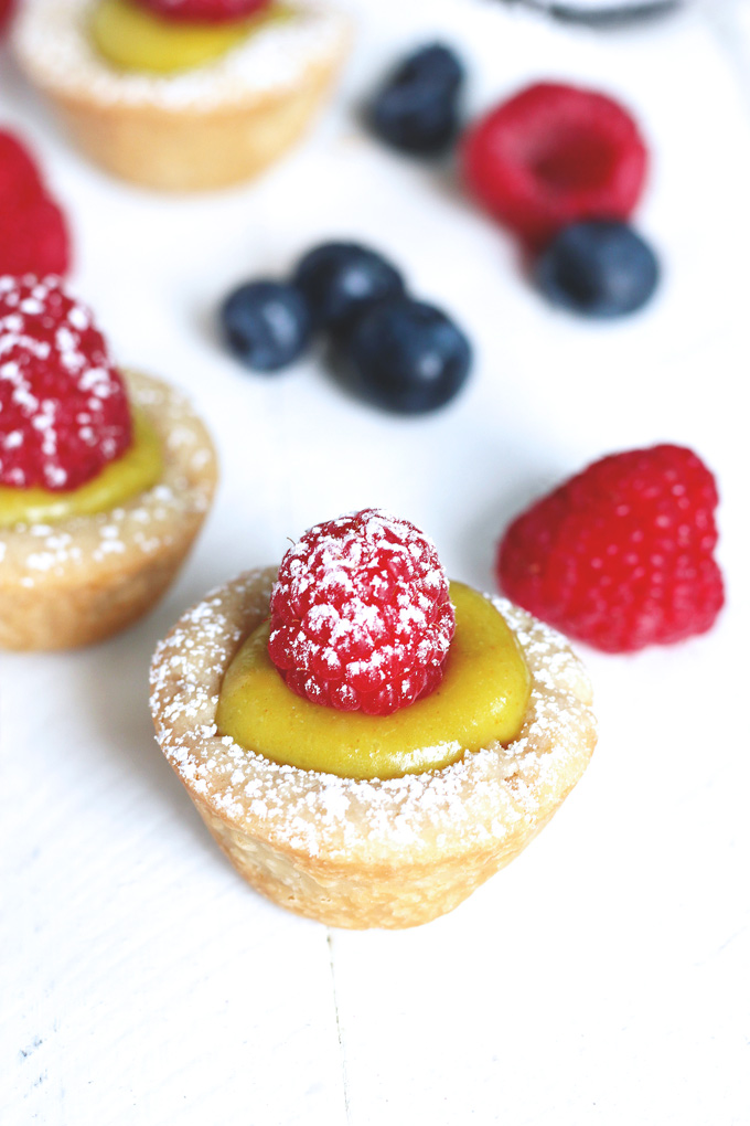 Mini Vegan Custard Tarts With Raspberry - These tarts are made with a cake crust and filled with a creamy, dreamy, heavenly vegan custard. Topped off with fresh raspberries and powdered coconut shreds for extra sparkle, making these bites sugar freakin' free! NeuroticMommy.com #vegan #healthysnacks