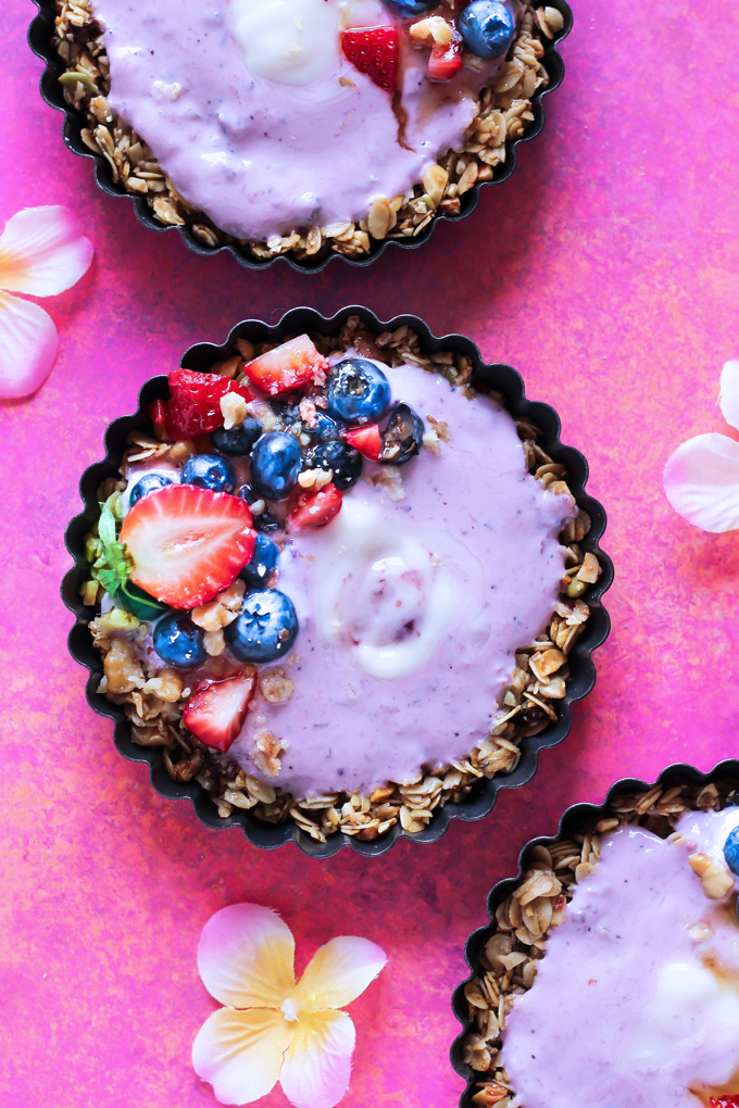 Nut and Seed Fruit Yogurt Tarts [Vegan] - These tarts not only look super pretty, they are filled with vegan blueberry yogurt and surrounded by an array of delicious mixed nuts like walnuts, almonds, sunflower seeds and peanuts. Add some fresh berries on top and enjoy this sweet treat as breakfast, snack or dessert. NeuroticMommy.com #healthy #vegan #easter #tarts 