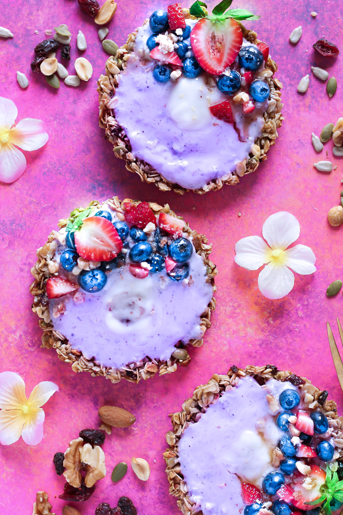 Nut and Seed Fruit Yogurt Tarts [Vegan] - These tarts not only look super pretty, they are filled with vegan blueberry yogurt and surrounded by an array of delicious mixed nuts like walnuts, almonds, sunflower seeds and peanuts. Add some fresh berries on top and enjoy this sweet treat as breakfast, snack or dessert. NeuroticMommy.com #healthy #vegan #easter #tarts 