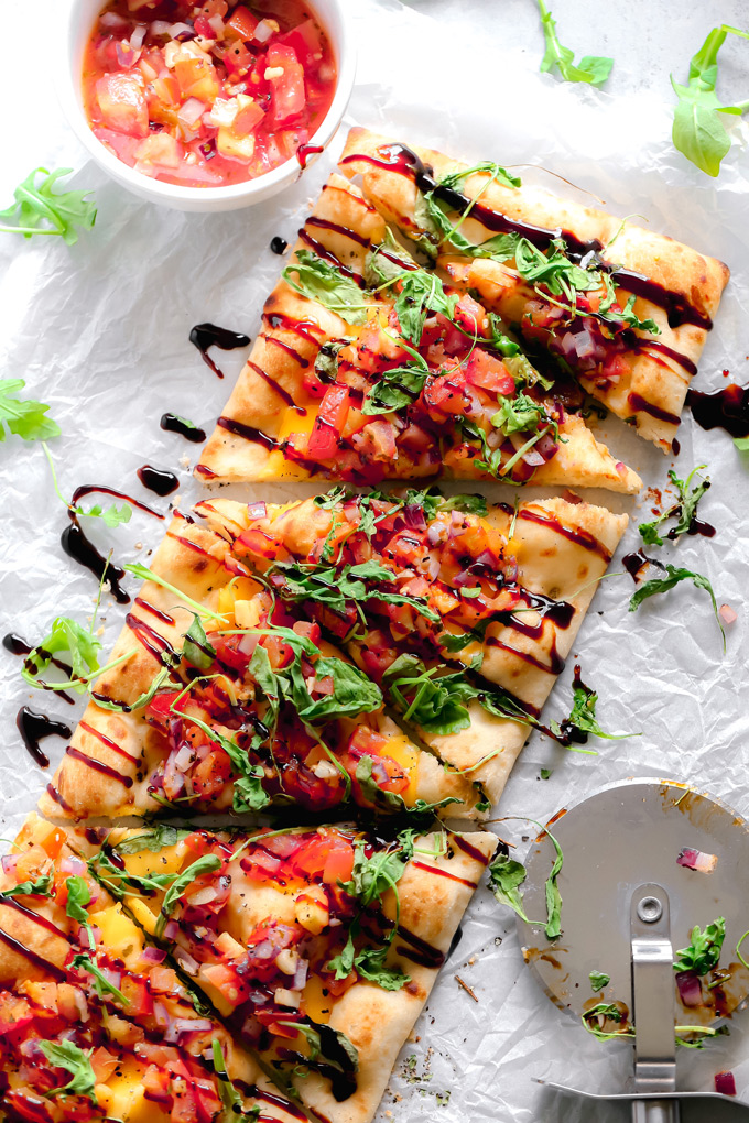 Vegan Bruschetta and Arugula Flatbread Pizza with a Balsamic glaze - Delicious easy recipe with immense flavor. Enjoy this homemade flatbread pizza using fresh bruschetta, arugula, vegan cheese, and a sweet balsamic glaze. NeuroticMommy.com #veganpizza