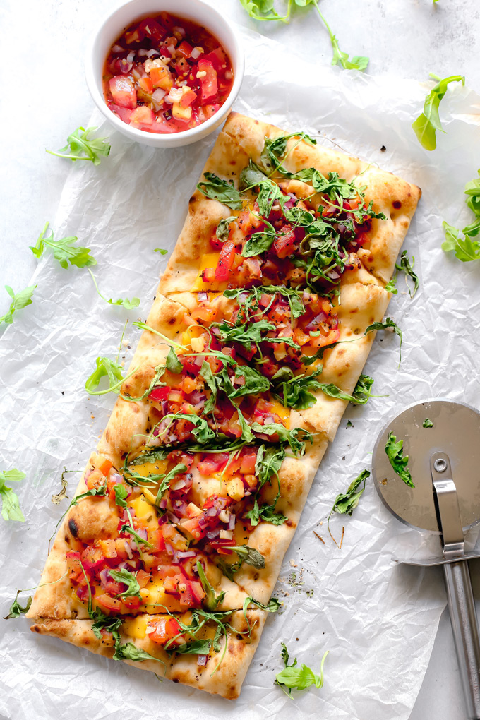 Vegan Bruschetta and Arugula Flatbread Pizza with a Balsamic glaze - Delicious easy recipe with immense flavor. Enjoy this homemade flatbread pizza using fresh bruschetta, arugula, vegan cheese, and a sweet balsamic glaze. NeuroticMommy.com #veganpizza