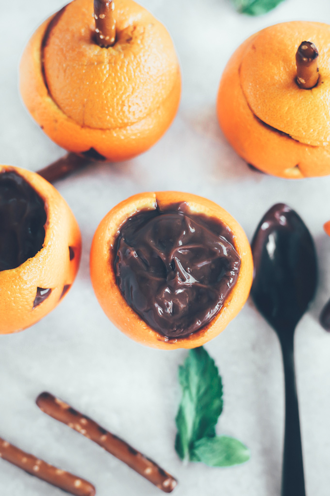 Vegan Chocolate Pudding Orange Jack O' Lanterns - Oranges filled with vegan chocolate pudding making this a fun healthy snack option for Halloween! NeuroticMommy.com #vegan #halloween #healthysnacks