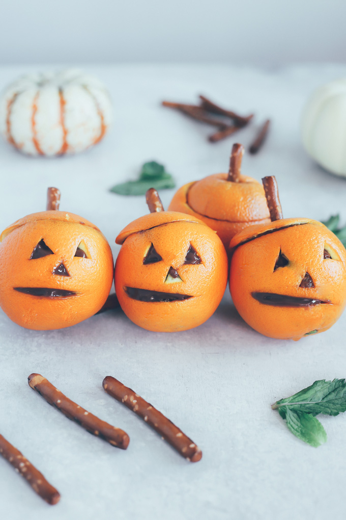 Vegan Chocolate Pudding Orange Jack O' Lanterns - Oranges filled with vegan chocolate pudding making this a fun healthy snack option for Halloween! NeuroticMommy.com #vegan #halloween #healthysnacks