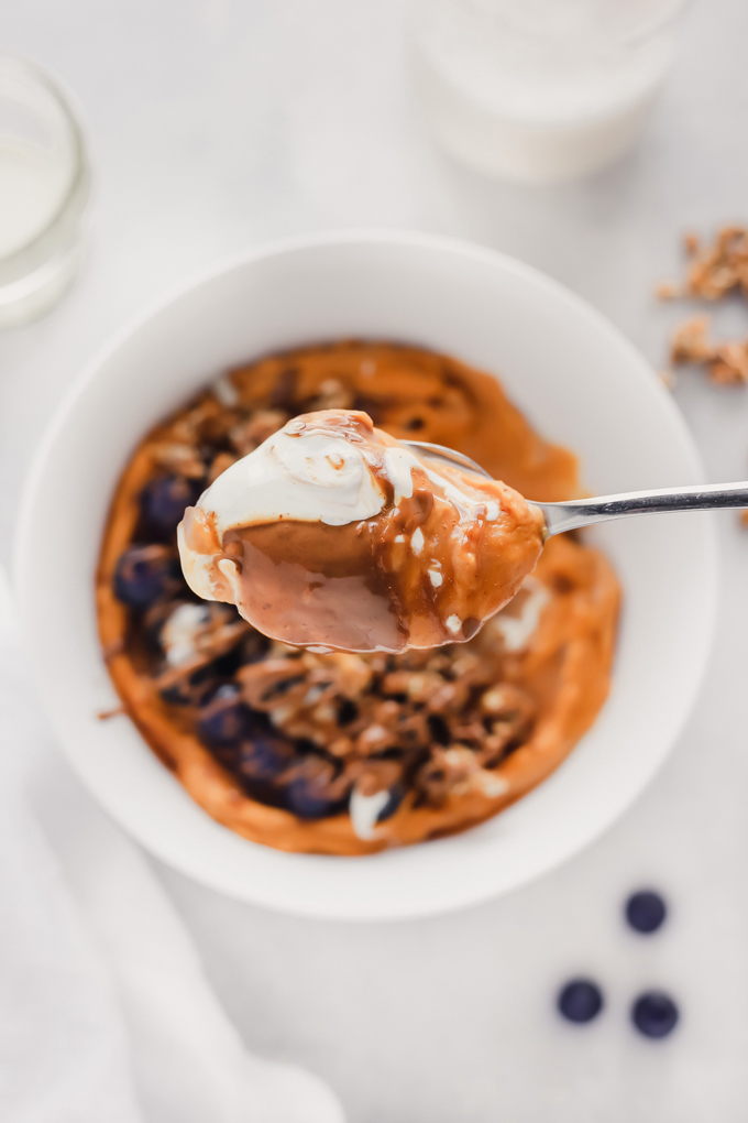 Vegan Sweet Potato Breakfast Bowl - Topped with blueberries, almond butter, and dairy free yogurt, this is packed with fiber, healthy fats and so easy to make! You can meal prep this and have it ready to go with all the right ingredients to fuel your day! NeuroticMommy.com #vegan #breakfast #sweetpotatoes