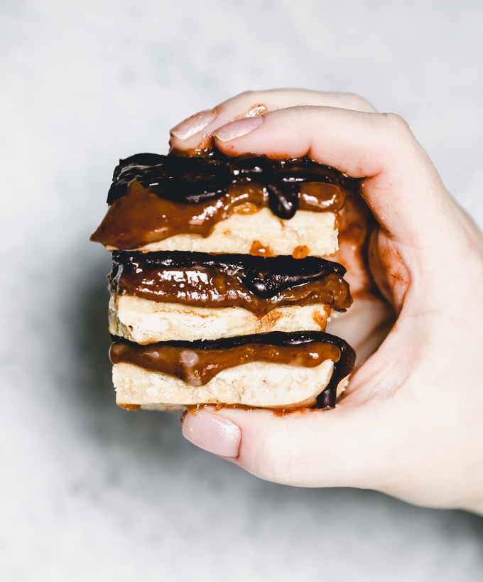 Homemade Vegan Twix Bars - A traditional shortbread crust layered with gooey caramel filling and a sweet dark chocolate topping. A delicious vegan remake to a classic recipe. NeuroticMommy.com #vegantwix