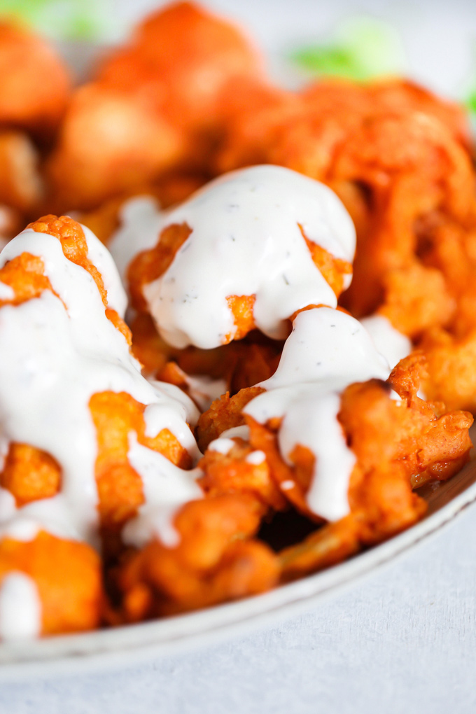 Vegan Cauliflower Buffalo Bites - Baked to crunchy perfection and smothered in vegan blue cheese, this is ready and set to go in under 30 minutes. NeuroticMommy.com #vegan #vegansnacks #buffalocauliflower 