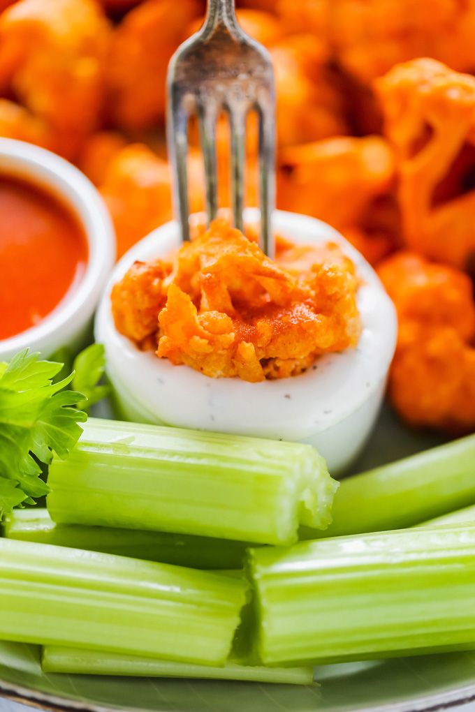 Vegan Cauliflower Buffalo Bites - Baked to crunchy perfection and smothered in vegan blue cheese, this is ready and set to go in under 30 minutes. NeuroticMommy.com #vegan #vegansnacks #buffalocauliflower 