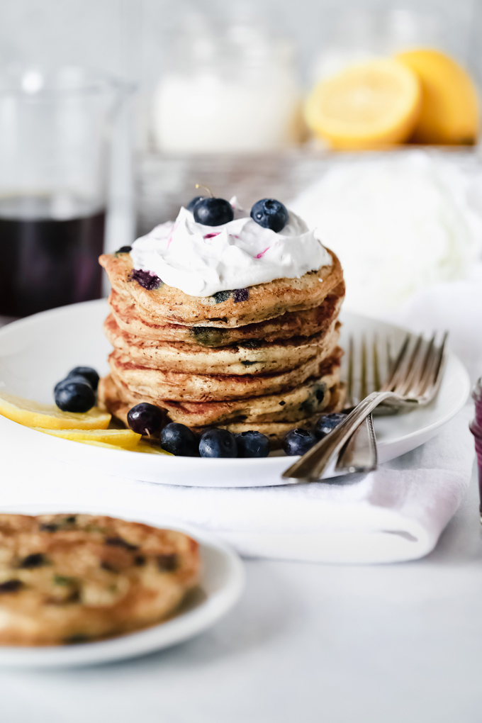 Vegan Blueberry Lemon Buttermilk Pancakes - The BEST VEGAN Fluffy Buttermilk Pancakes you'll ever try! With blueberries and lemon in every bite and topped with coconut whip cream, maple syrup and a blueberry compote. NeuroticMommy.com #vegan #pancakes