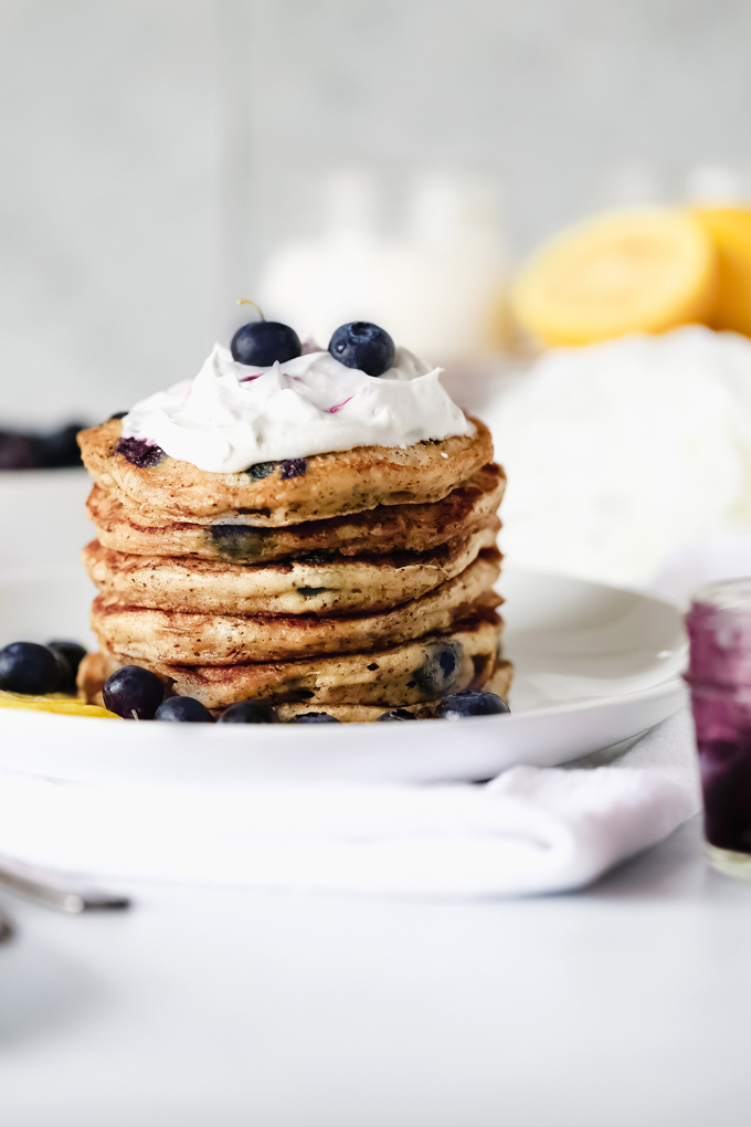 Vegan Blueberry Lemon Buttermilk Pancakes - The BEST VEGAN Fluffy Buttermilk Pancakes you'll ever try! With blueberries and lemon in every bite and topped with coconut whip cream, maple syrup and a blueberry compote. NeuroticMommy.com #vegan #pancakes