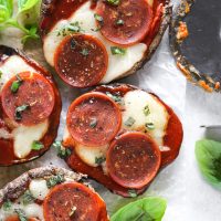 Vegan Keto Portobello Mushroom Pizzas are stuffed with vegan mozzarella, a keto friendly marinara sauce thats sugar free and topped with vegan pepperoni and sprinkles of basil. Perfect for your keto meals and hits the spot with pizza cravings! NeuroticMommy.com #keto #vegan