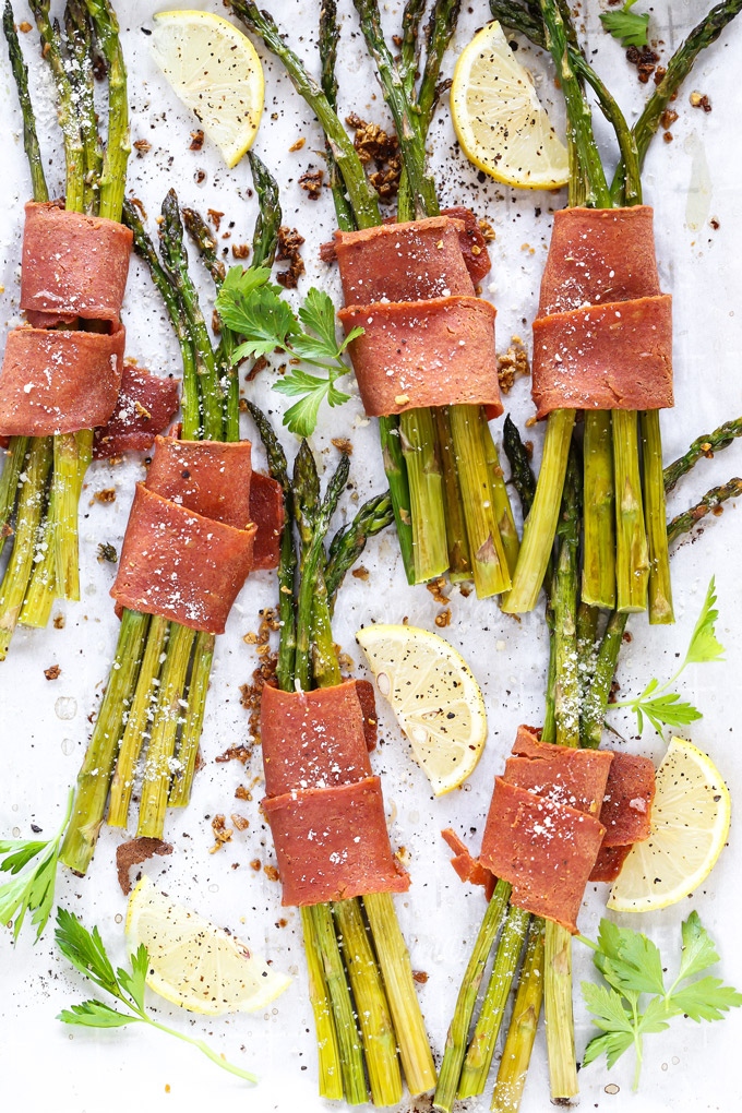 Vegan Bacon Wrapped Asparagus - Super easy and delicious low carb, vegan keto friendly side dish to make anytime. Crispy bacon wrapped around asparagus topped with vegan parmesan and a sprinkle of lemon is all sorts of perfect. NeuroticMommy.com #vegan #thanksgiving #veganketo #keto