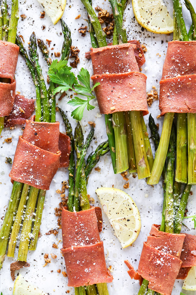 Vegan Bacon Wrapped Asparagus - Super easy and delicious low carb, vegan keto friendly side dish to make anytime. Crispy bacon wrapped around asparagus topped with vegan parmesan and a sprinkle of lemon is all sorts of perfect. NeuroticMommy.com #vegan #thanksgiving #veganketo #keto