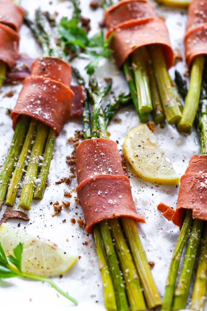 Vegan Bacon Wrapped Asparagus - Super easy and delicious low carb, vegan keto friendly side dish to make anytime. Crispy bacon wrapped around asparagus topped with vegan parmesan and a sprinkle of lemon is all sorts of perfect. NeuroticMommy.com #vegan #thanksgiving #veganketo #keto