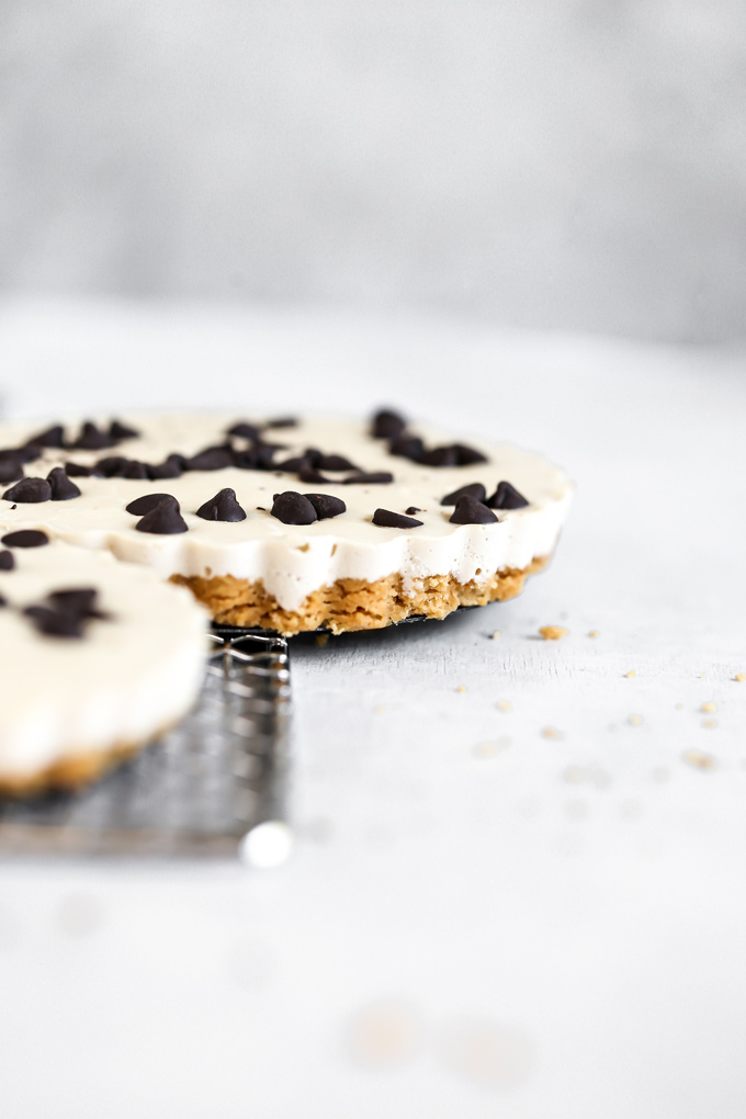 Vegan White Chocolate Fudge Cheesecake - In celebration of NeuroticMommy's 6th birthday, this creamy, indulgent deliciousness is made with a vegan buttery crust, creamy cacao butter makes up the white chocolate center, topped with dairy free chocolate chips, this is a must make! NeuroticMommy.com #vegan #keto #cheesecake